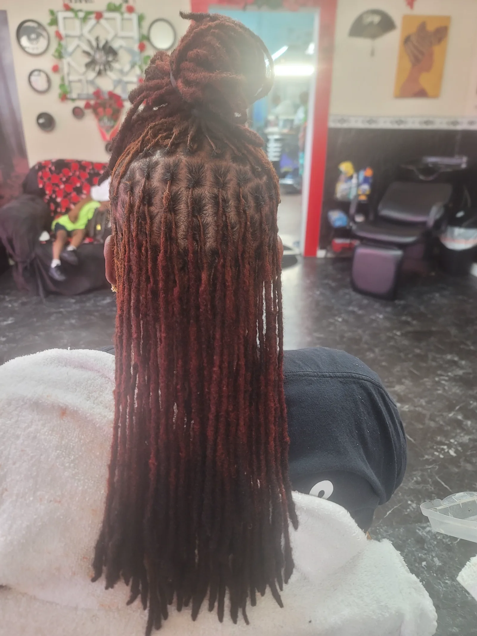 Long burgundy locs styled at Mo'Hair Beauty Salon